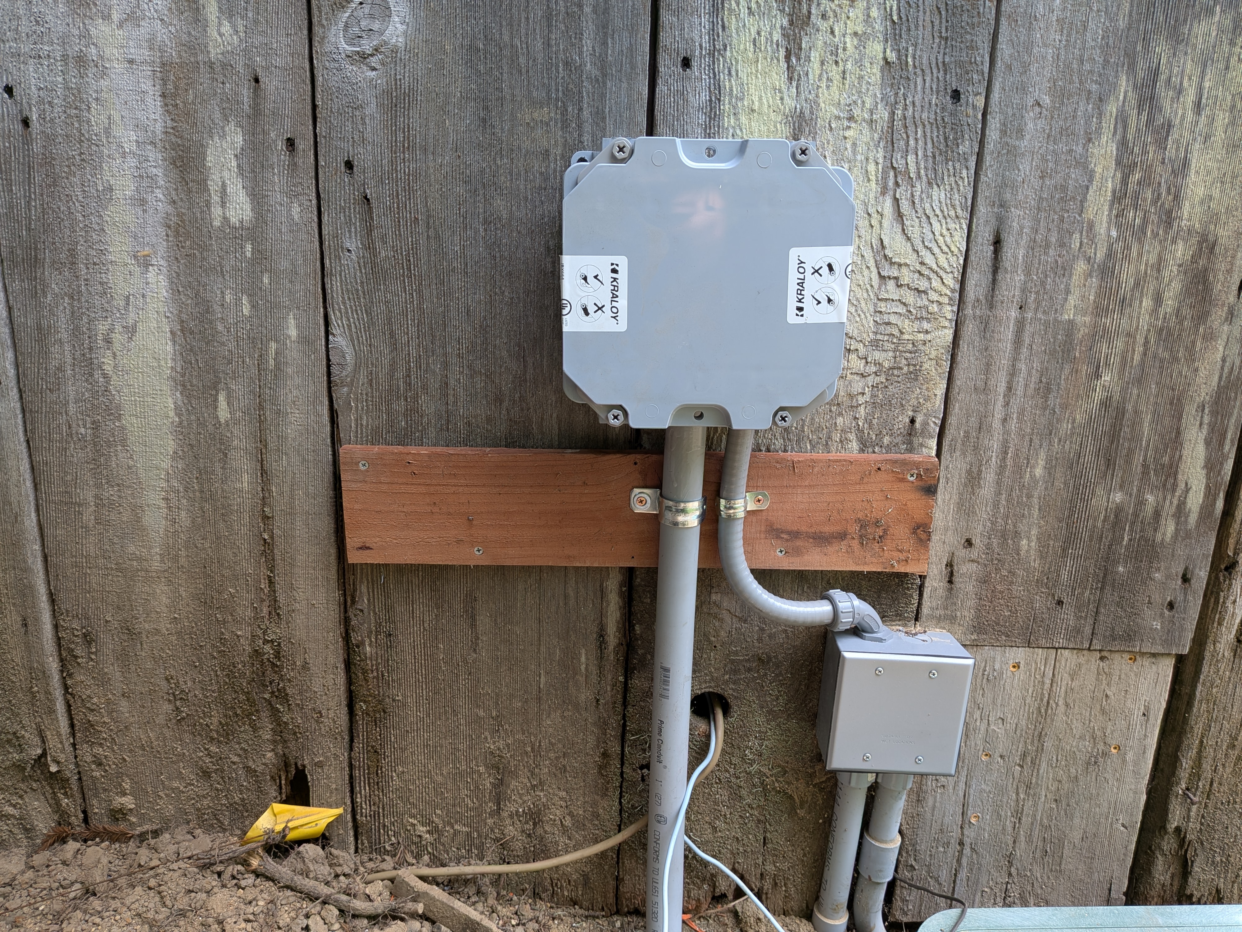 Photo of new electrical box, closed up with piping strapped down
